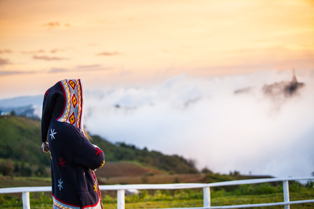 Young woman on a hill  looking the sunset.の写真素材