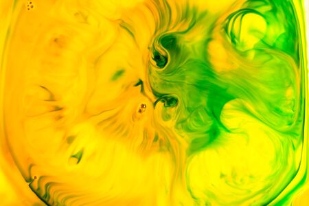 Yellow and green oil paint on water abstract background.の写真素材