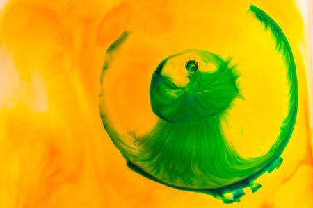 Yellow and green oil paint on water abstract background.の写真素材