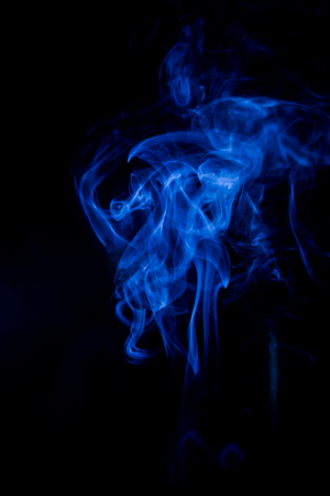 Blue toxic fumes movement on a black background.の写真素材