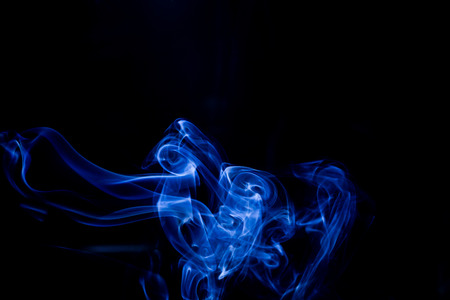 Blue toxic fumes movement on a black background.の写真素材