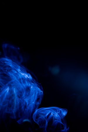Blue toxic fumes movement on a black background.の写真素材