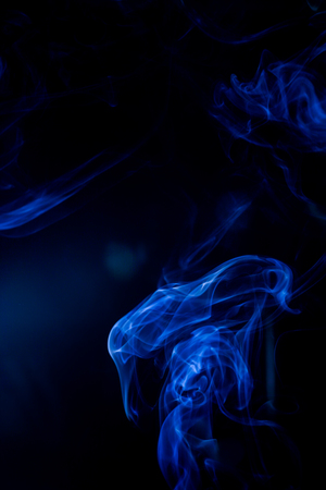 Blue toxic fumes movement on a black background.の写真素材