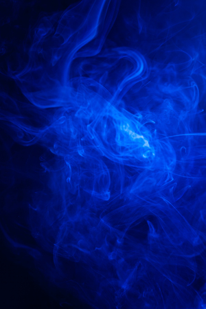 Blue smoke on black background.の写真素材