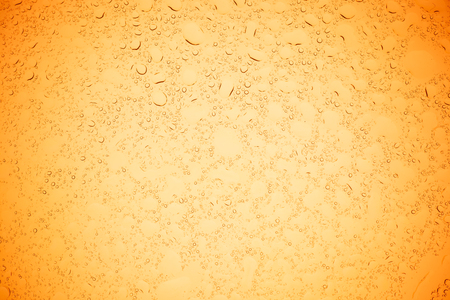 Rain droplets on yellow glass background, Water drops on yellow glass.の写真素材