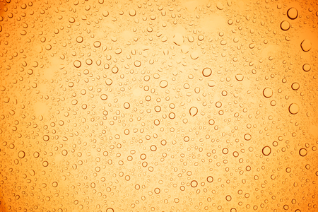 Rain droplets on yellow glass background, Water drops on yellow glass.の写真素材