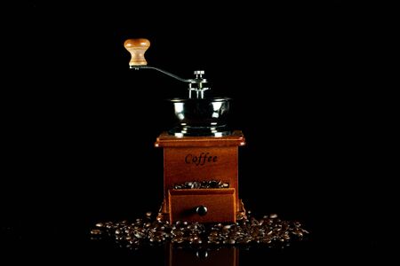 Coffee beans and vintage wooden coffee grinder on black background.の写真素材