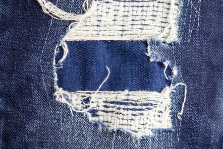 Blue torn denim jeans texture background.