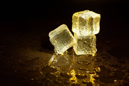 ice cubes on a reflections yellow light.の写真素材