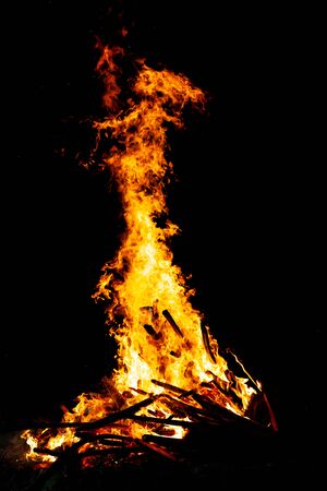 Bonfire that burns on a dark background, wood burning flame.