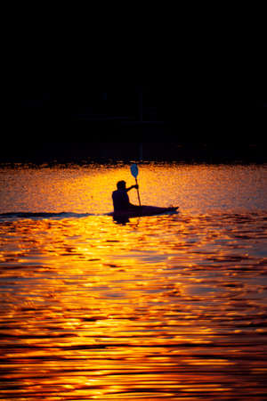 Rowing athletes train for victory in the evening during the low sun before the horizon.の写真素材