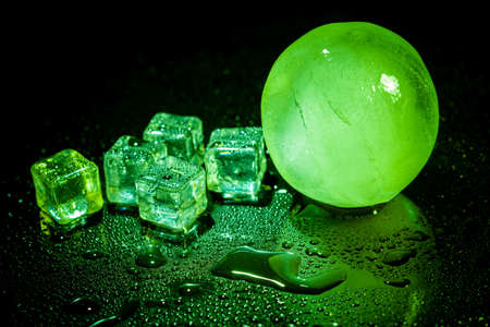 Green ice ball reflection on black background.の写真素材