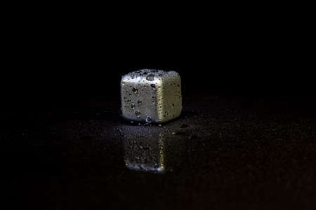 Red ice cubes reflection on black table background.の写真素材