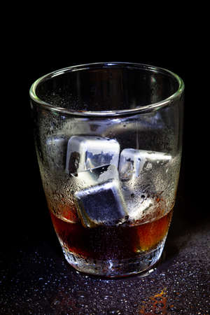 Red ice cubes reflection on black table background.の写真素材