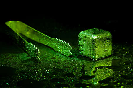 Red ice cubes reflection on black table background.の写真素材
