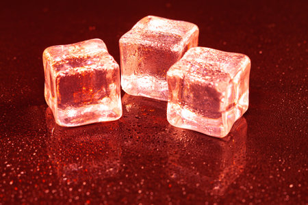 Red ice cubes on black background.の写真素材