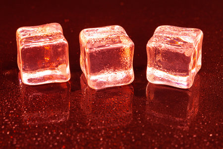 Red ice cubes on black background.の写真素材