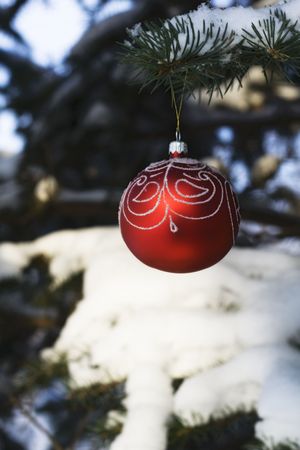Christmas tree decoration handing on fir tree covered with snow