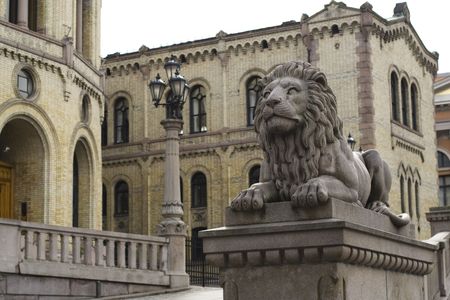 Sculpture of Lion with the Norwegian Parliament building in background. Oslo cityの写真素材