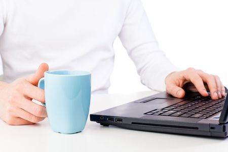 Working on computer. Hand with cup of coffeeの写真素材