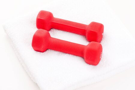 Two red dumbbells and white sport towelの写真素材