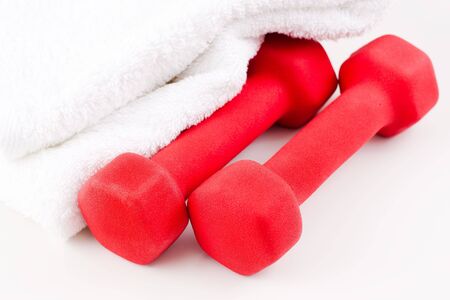 Two red dumbbells and white sport towelの写真素材