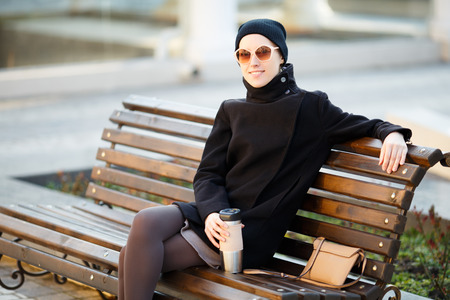 fashionable young woman posing outside in a city streetの写真素材