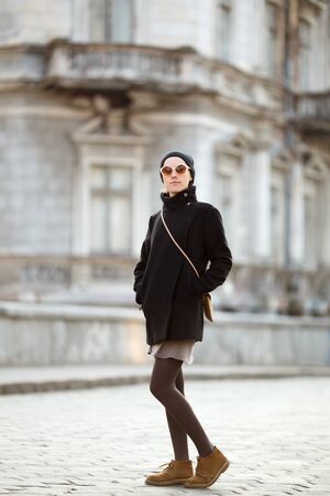 fashionable young woman posing outside in a city streetの写真素材