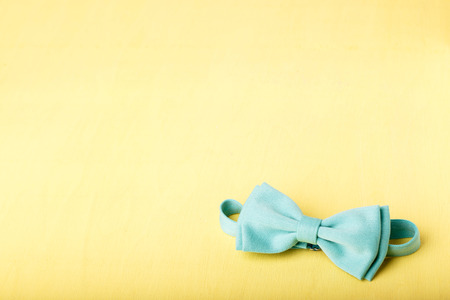 blue bow tie on yellow wooden tableの写真素材