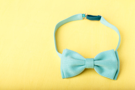 blue bow tie on yellow wooden tableの写真素材