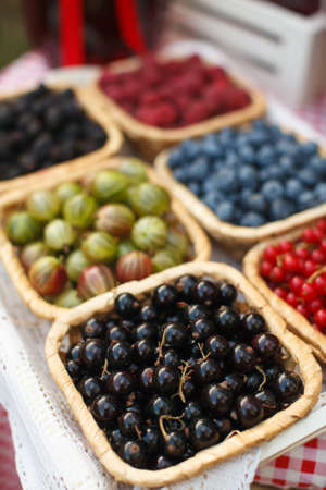 Summer berries in the buckets on the tableの写真素材