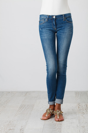 Woman in blue skinny jeans on the white backgroundの写真素材
