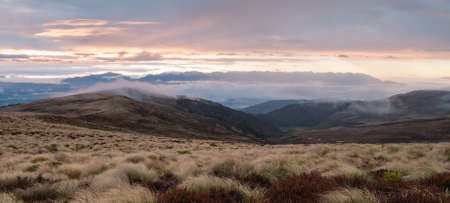 Foggy sunrise over the valleys on Kepler Track ,wide shot, Fiordland National Park, New Zealandの写真素材