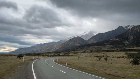 Road leading towards mountains, with cloudy sky. High perspective shot made in Aoraki Mt Cook National Park in New Zealandの写真素材