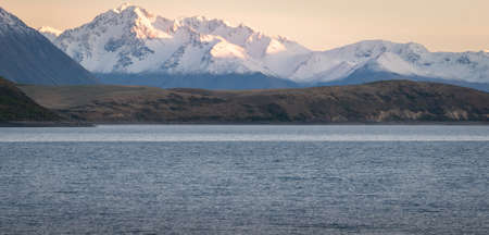 Mountain range during sunrise with lake in foreground, shot at Lake Tekapo, New Zealandの写真素材