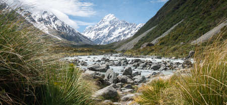 Panorama shot of glacier river leading to mountain in background made on sunny day. Shot in Aoraki...
