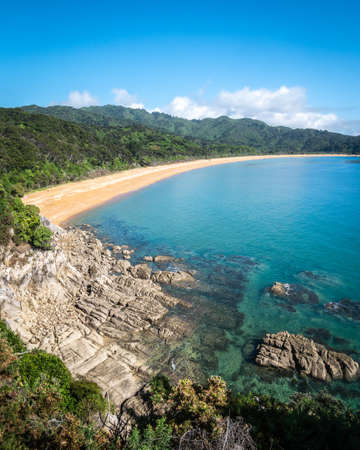 View on the tropical beach with golden sands and azure waters. Portrait shot made in Abel Tasman National Park, New Zealandの写真素材