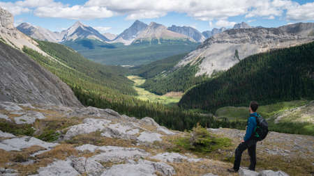 Male hiker enjoying the view over alpine valley in Kananaskis, Canadian Rockies, Canadaの写真素材