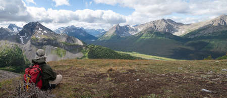 Hiker resting and enjoying autumn panorama and views over the valley in Canadian Rockies, Canadaの写真素材