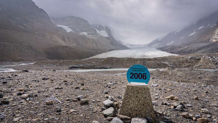 Disappearing glacier surrounded by mountains with sign in the front, Jasper National Park, Canadaの写真素材