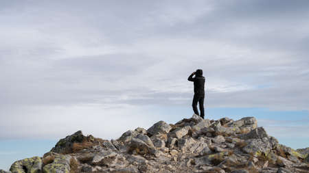 Man using binoculars on the mountain summit, Slovakia, Europeの写真素材