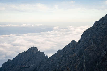 Rocky mountain ridge towering above the clouds during sunset, Slovakia, Europeの写真素材