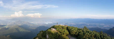 Man standing on the top of the mountain enjoying the views on valley beneath him, Slovakia, Europeの写真素材