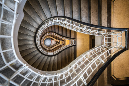 Abstract top down view of historical staircase curling through several floors, Prague, Czechia