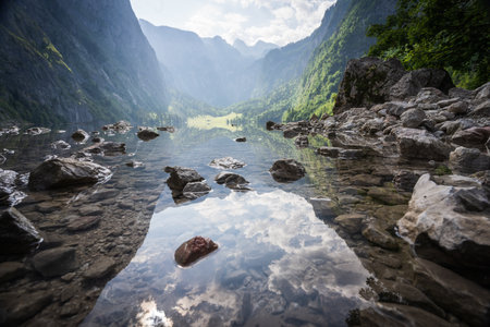 Pristine alpine lake nested amongst mountains and high stone walls, Obersee, Germanyの写真素材
