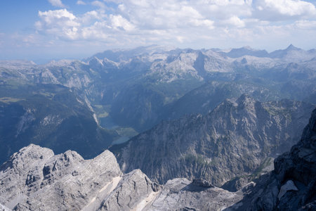 Alpine landscape with mountain ranges and lakes viewed from high mountain summit, Watzmann, Germanyの写真素材