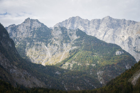 Layers of mountains with forest and rocky ridges with some autumn colours, Obersee, Germanyの写真素材
