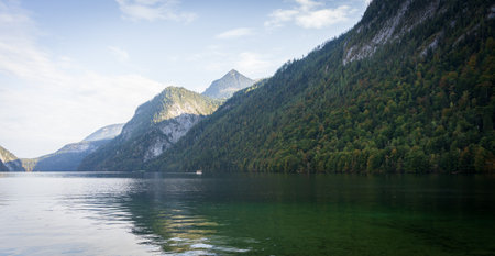 Boat sailing on green alpine lake surrounded with mountains , Konigsee, Germany