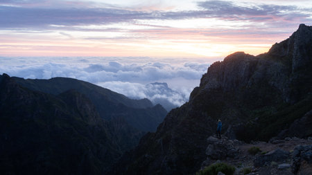Hiker enjoying views on beautiful mountainous landscape during colorful sunrise, Madeira, Portugalの写真素材