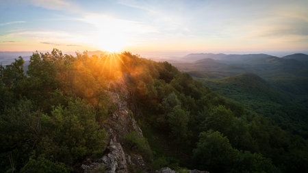 Sun rising over beautiful hilly landscape with rocks, deciduous forest and trees, Slovakia, Europeの写真素材